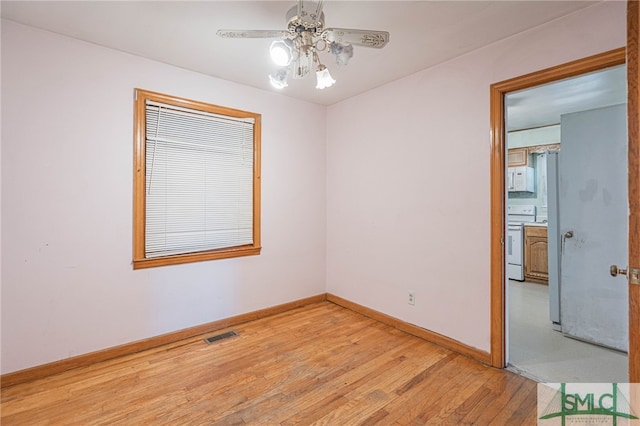 empty room with light wood-style floors, visible vents, baseboards, and ceiling fan