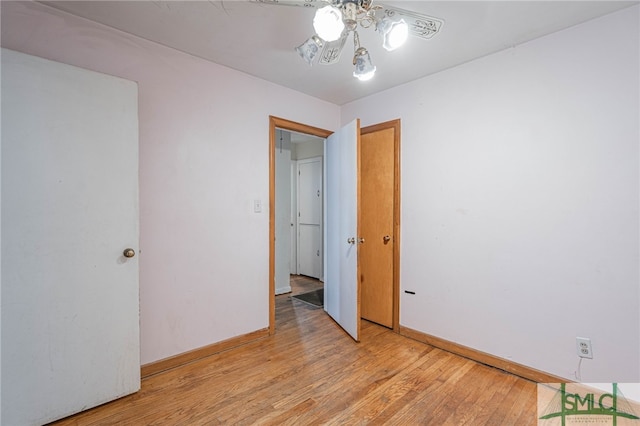 spare room featuring light wood-type flooring and baseboards