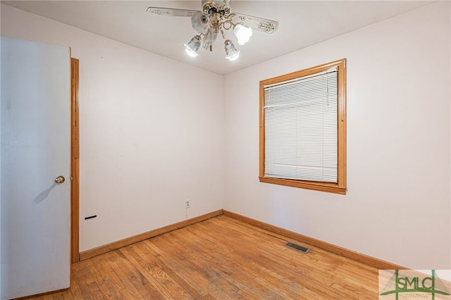 unfurnished room with ceiling fan, light wood finished floors, visible vents, and baseboards