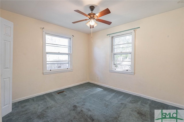 unfurnished room with visible vents, dark carpet, baseboards, and ceiling fan