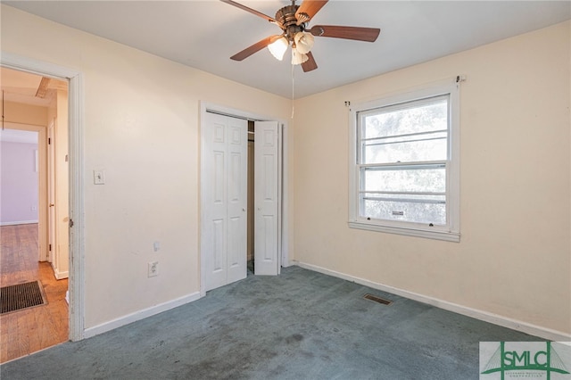 unfurnished bedroom with a closet, visible vents, attic access, carpet flooring, and baseboards