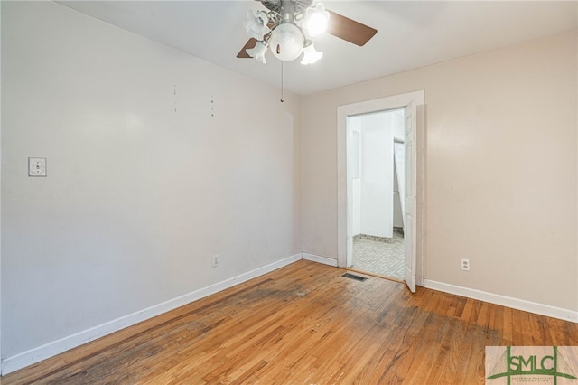 spare room featuring ceiling fan, light wood-type flooring, visible vents, and baseboards