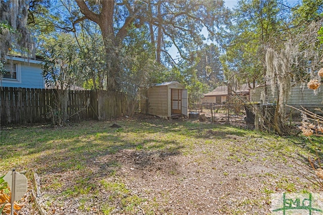 view of yard featuring an outbuilding, a fenced backyard, and a storage shed