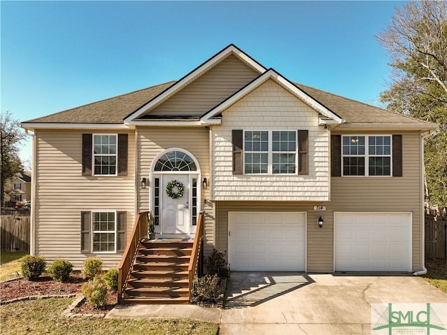 bi-level home with a garage and concrete driveway