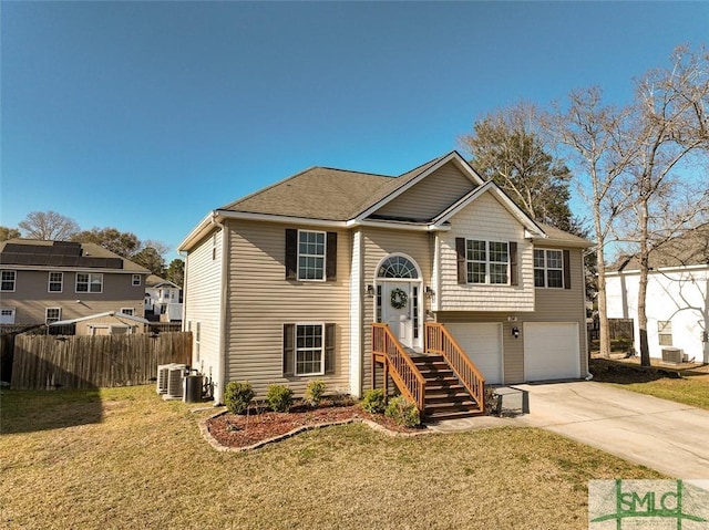 split foyer home with driveway, central AC, a front yard, and fence