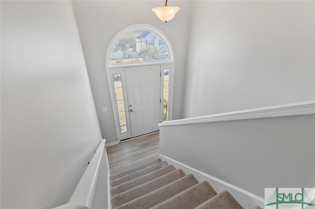 entryway featuring stairs, baseboards, and wood finished floors