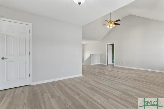 unfurnished living room featuring high vaulted ceiling, light wood-style flooring, baseboards, and a ceiling fan