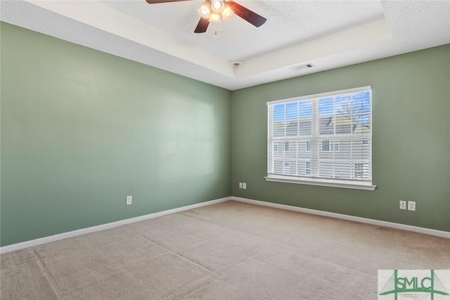 spare room with carpet floors, visible vents, a textured ceiling, and baseboards