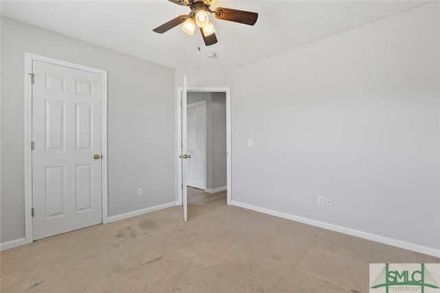 unfurnished bedroom with carpet, baseboards, and a ceiling fan