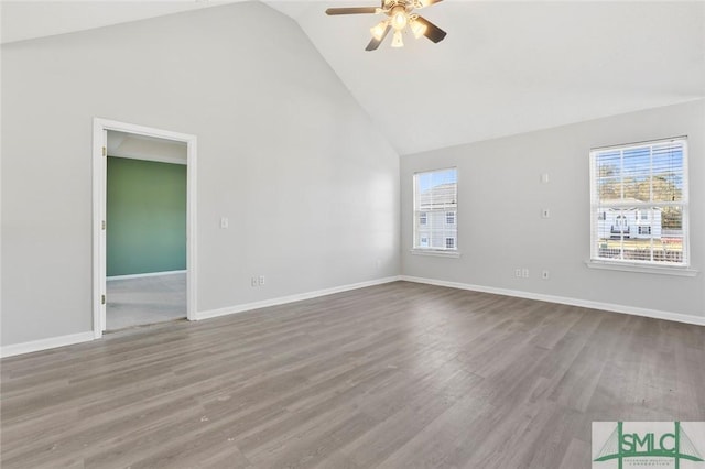 unfurnished room featuring high vaulted ceiling, baseboards, a wealth of natural light, and wood finished floors