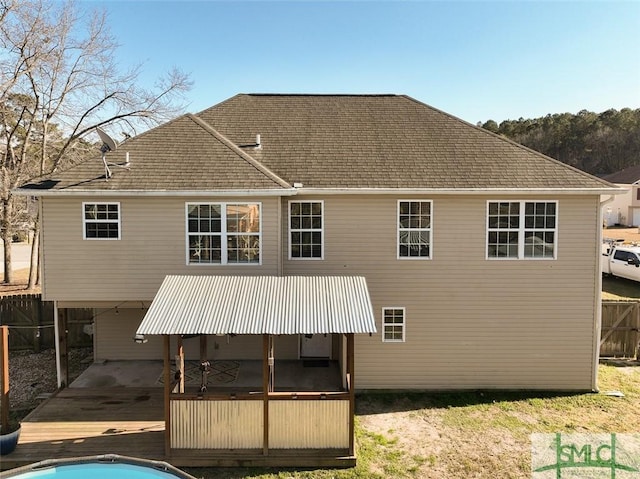 back of house featuring a carport and fence