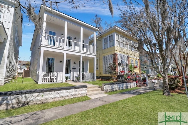 view of front of house with a porch, a front yard, and a balcony