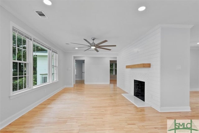 unfurnished living room featuring recessed lighting, visible vents, ornamental molding, a large fireplace, and light wood-type flooring