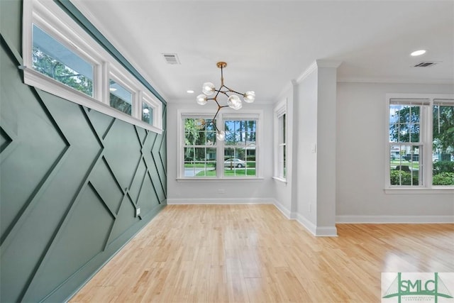 interior space with light wood-style floors, baseboards, visible vents, and crown molding