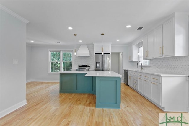 kitchen featuring appliances with stainless steel finishes, light countertops, custom range hood, and backsplash