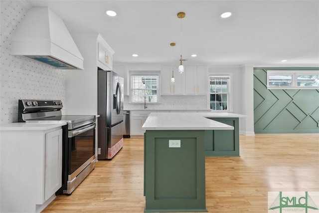 kitchen with white cabinets, green cabinets, appliances with stainless steel finishes, custom exhaust hood, and a center island