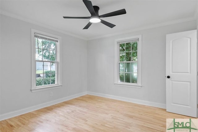 spare room featuring light wood-style floors, baseboards, and crown molding