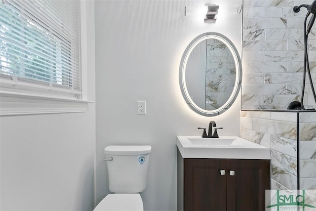 bathroom featuring toilet, walk in shower, and vanity