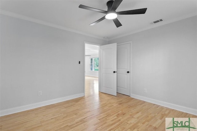 unfurnished bedroom featuring ornamental molding, light wood-type flooring, visible vents, and baseboards