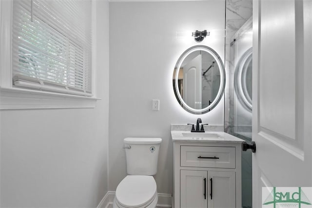 bathroom featuring vanity, toilet, and baseboards