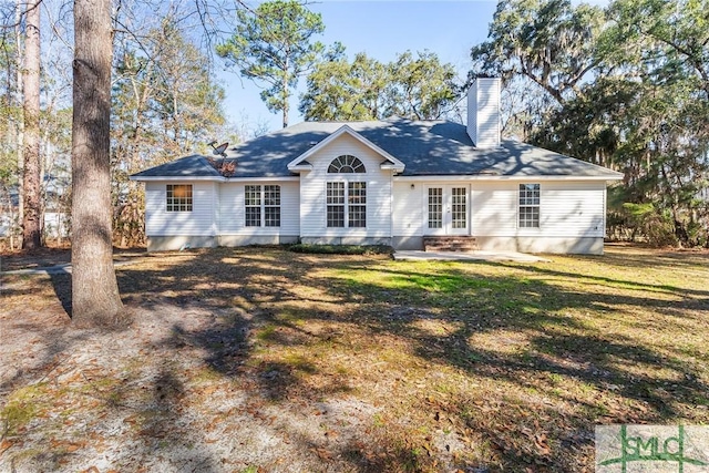 view of front of property with a chimney, a front lawn, and french doors