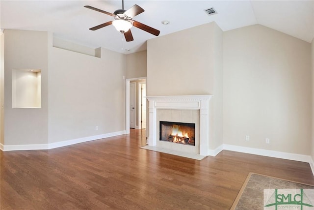 unfurnished living room featuring visible vents, baseboards, lofted ceiling, wood finished floors, and a fireplace