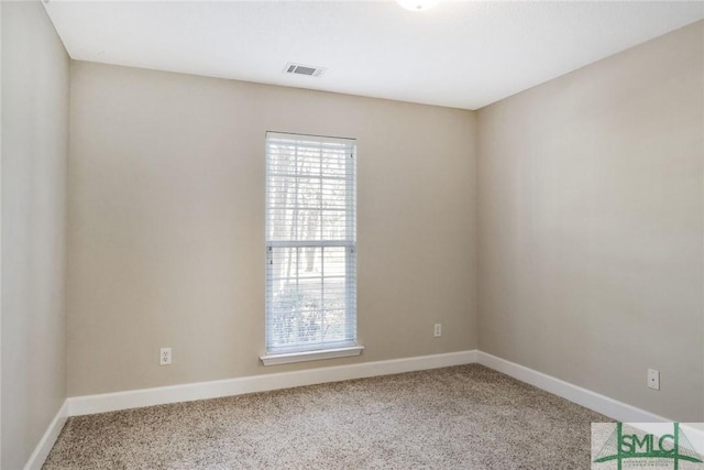 empty room featuring carpet, visible vents, and baseboards