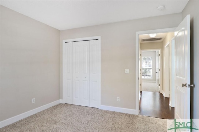 unfurnished bedroom with carpet, visible vents, and baseboards