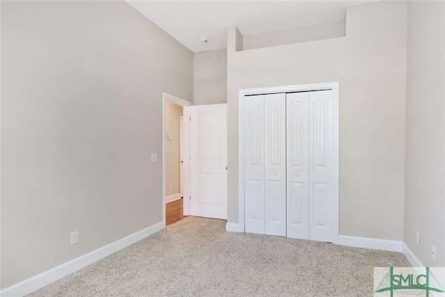 unfurnished bedroom with carpet, baseboards, and a closet