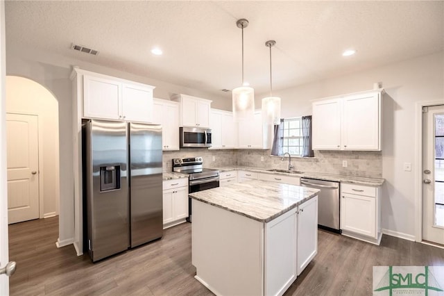 kitchen featuring stainless steel appliances, a sink, visible vents, and white cabinets