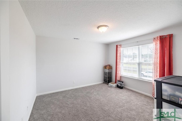 interior space featuring a textured ceiling, baseboards, and carpet flooring