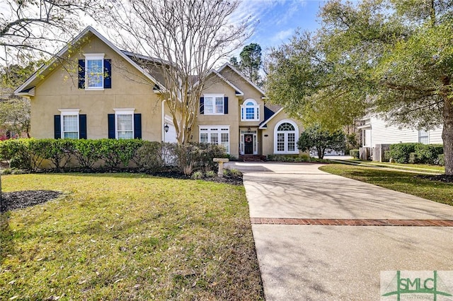 traditional-style home with concrete driveway, a front lawn, and stucco siding