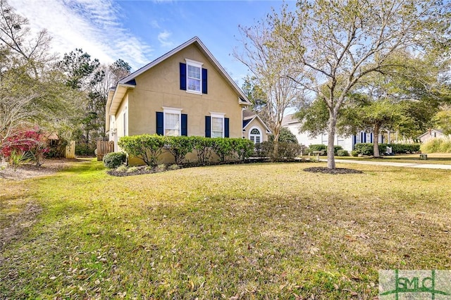 view of side of home featuring a lawn and stucco siding