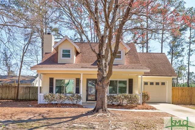 new england style home with a porch, fence, driveway, and an attached garage