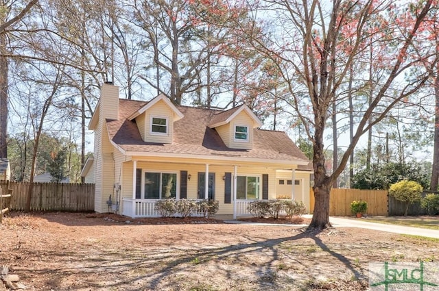 cape cod house featuring a porch, an attached garage, fence, roof with shingles, and a chimney