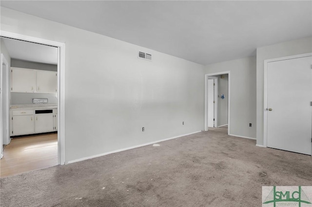 unfurnished bedroom featuring light carpet, baseboards, and visible vents