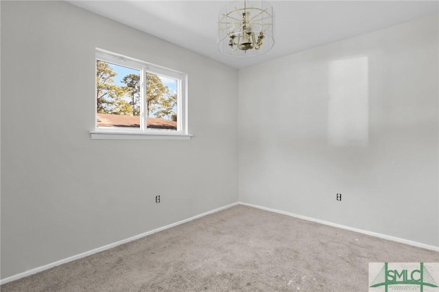 spare room with an inviting chandelier, carpet, and baseboards