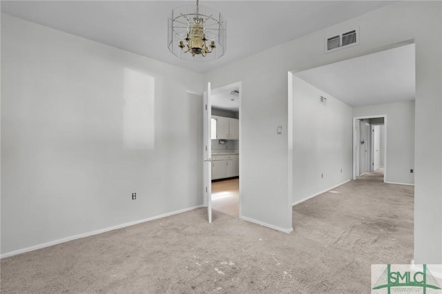 unfurnished bedroom featuring baseboards, carpet, visible vents, and a notable chandelier