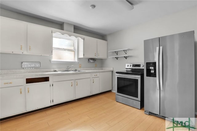 kitchen with open shelves, appliances with stainless steel finishes, a sink, and light countertops