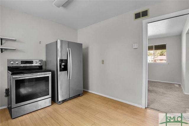 kitchen featuring appliances with stainless steel finishes, visible vents, light wood-style floors, and baseboards