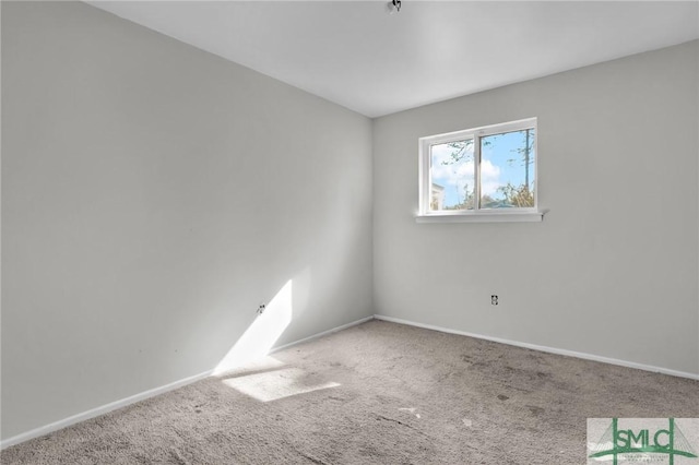 empty room featuring carpet floors and baseboards