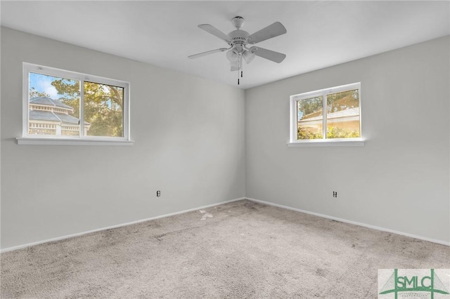 spare room with a ceiling fan, carpet flooring, and baseboards