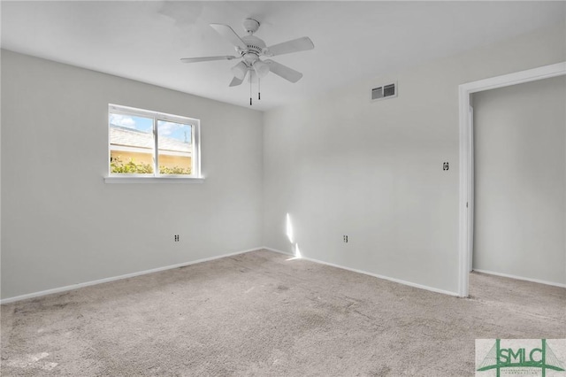 carpeted spare room with a ceiling fan, visible vents, and baseboards