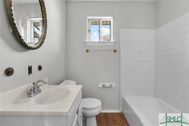 full bath with baseboards, vanity, toilet, and wood finished floors