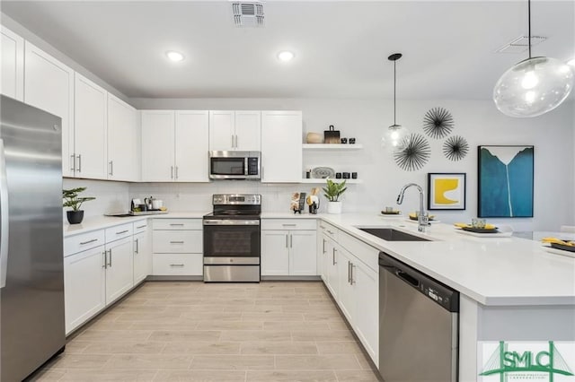 kitchen with a peninsula, visible vents, appliances with stainless steel finishes, and a sink