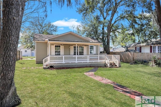 bungalow-style house with fence and a front lawn