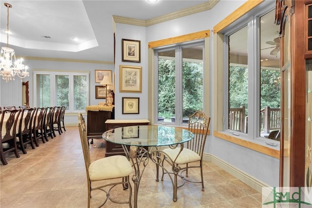 dining room featuring a notable chandelier, visible vents, baseboards, a tray ceiling, and crown molding