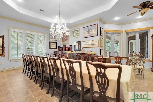 dining space with a raised ceiling, a healthy amount of sunlight, visible vents, and baseboards