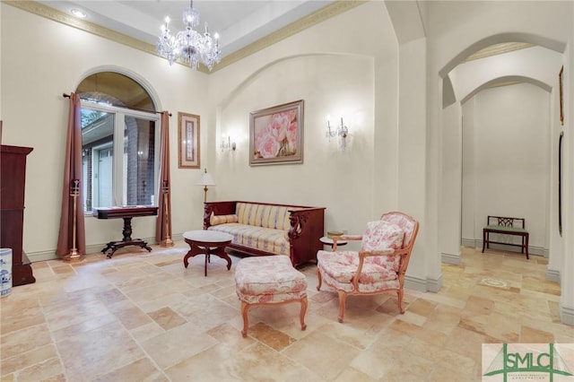 sitting room with a chandelier, arched walkways, and stone finish floor