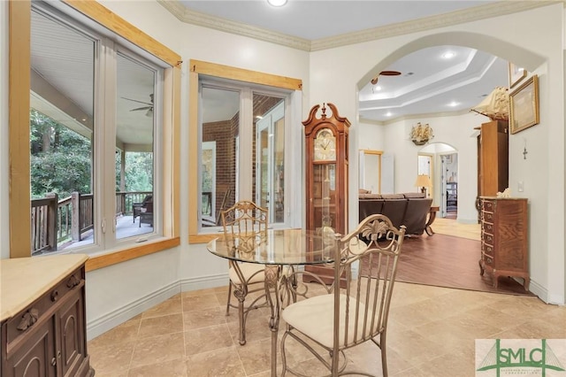 dining area featuring baseboards, arched walkways, and ornamental molding